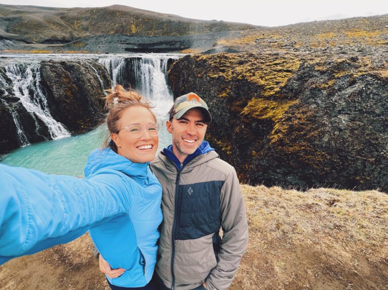 happy couple taking selfie in Iceland in front of a waterfall