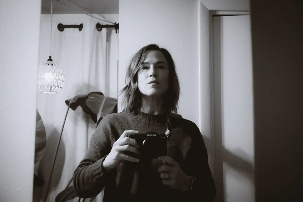 A black and white self portrait in a mirror with the Fujifilm X-T5