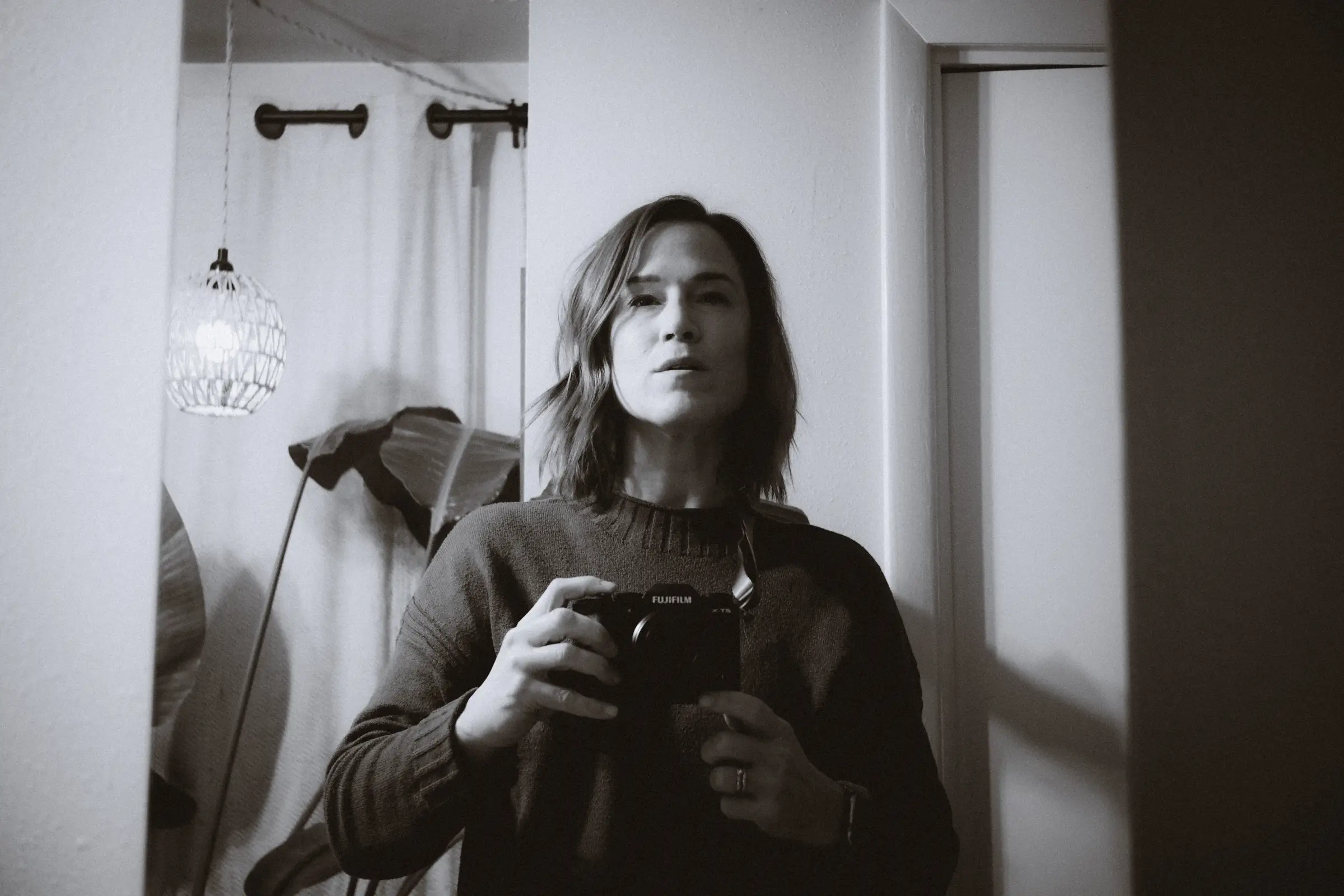 A black and white self portrait in a mirror with the Fujifilm X-T5